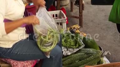 女人沿着城市人行道卖蔬菜